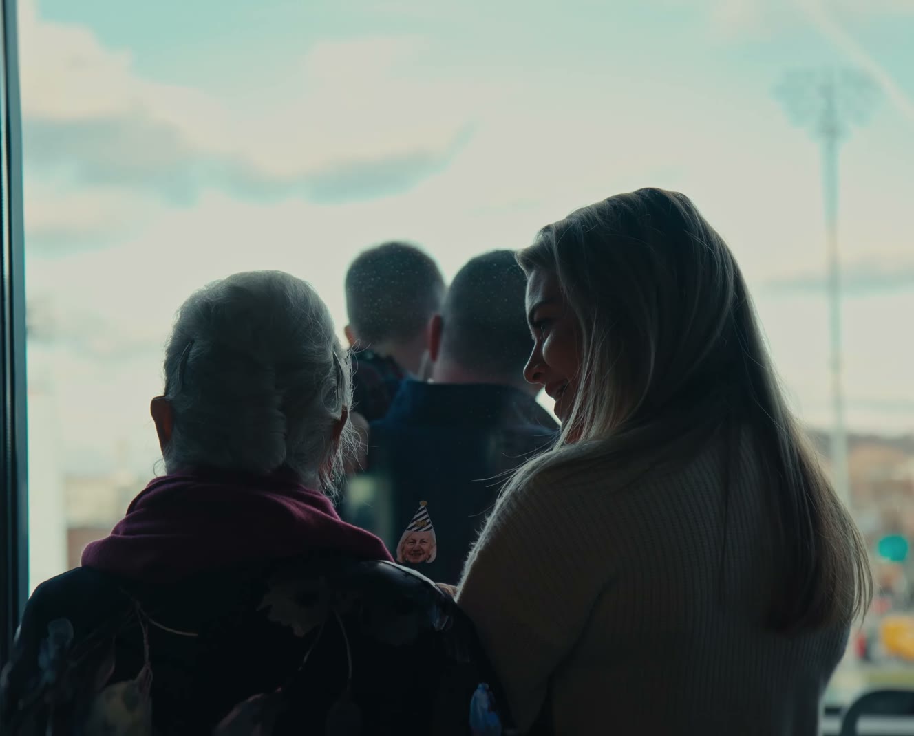 Guests at a window during a 90th birthday celebration